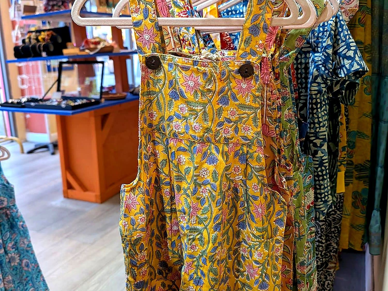 A rail of finished Genki Kids dresses in the shop, tagged and ready to send